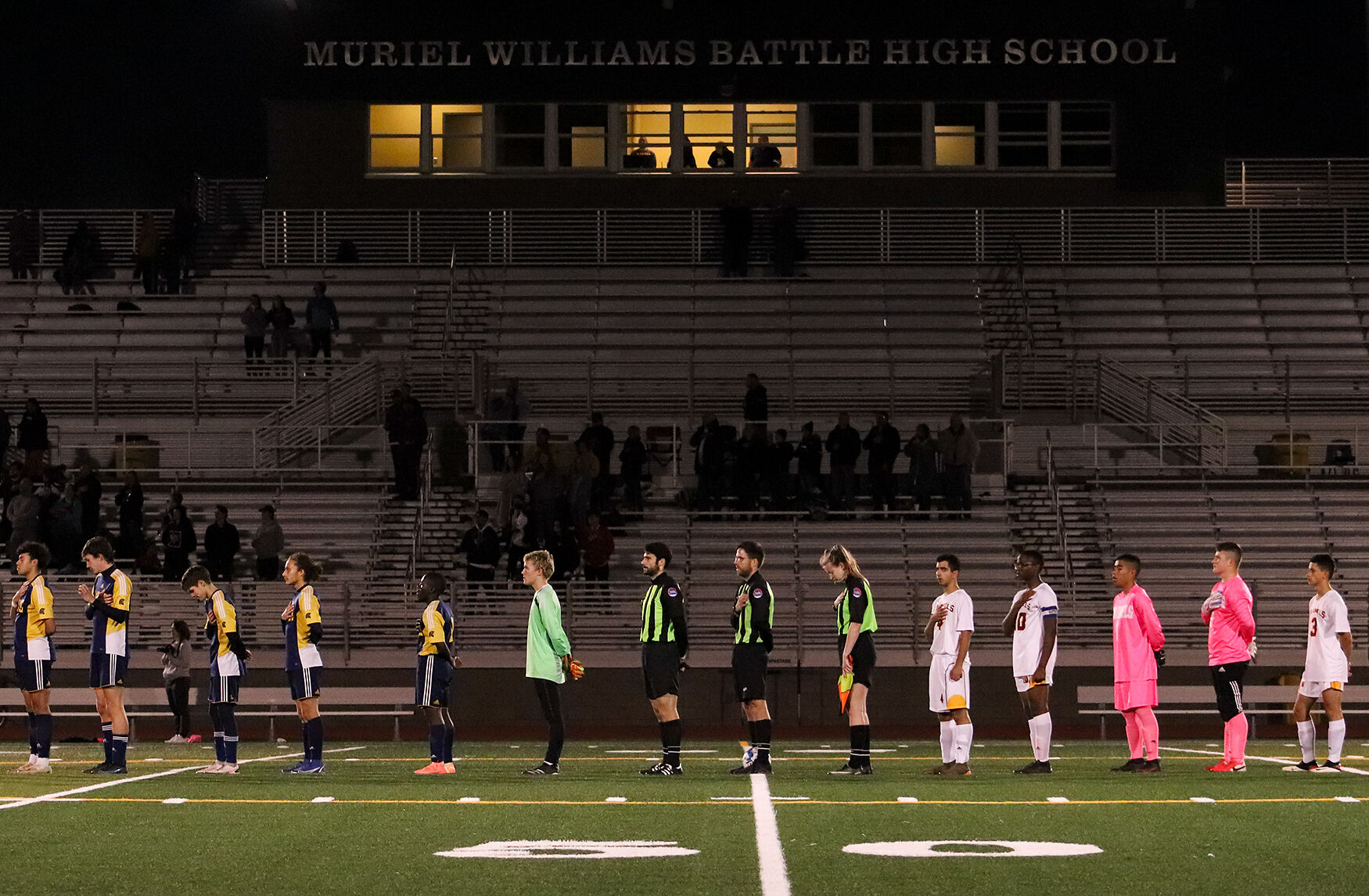 Players and referees stand for the national anthem